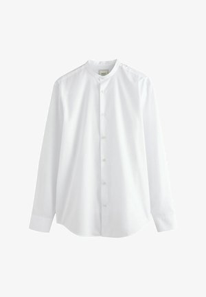 Balta ilga rankovė marškiniai su apvaliu apykakle, mygtukų priekyje ir lygaus medvilninio audinio. Yra ilgos rankovės ir suapvalintas kraštas.