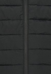 Jachetă puffer neagră cu textură matlasată, având linii verticale, un fermoar central și un finisaj din material neted. Fără logo-uri sau modele vizibile.