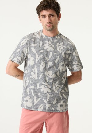 Kurzärmeliges T-Shirt mit Rundhalsausschnitt aus grauem Stoff mit weißem Blumenmuster. Es besitzt eine lockere Passform mit subtiler Textur und weichem Finish.