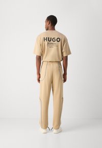 HUGO NIPIPEPANT - Pantalones deportivos - medium beige