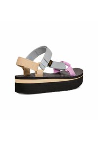 Le sandali platform presentano cinturini grigi, beige e rosa con una suola in gomma testurizzata. La base ha colori sovrapposti: nero, crema e marrone.