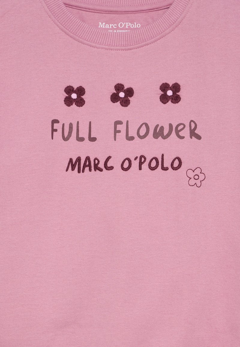 Różowa bluza z haftowanym napisem "FULL FLOWER" oraz "MARC O'POLO", ozdobiona motywami kwiatowymi i ściągaczem przy dekolcie. Miękka, bawełniana tkanina.