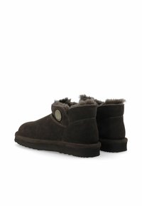 Braune Wildleder-Ankle Boots mit einem kuscheligen Futter aus Fell. Sie verfügen über eine runde Schuhspitze, eine flache Sohle und ein Knopfdetail an der Seite.
