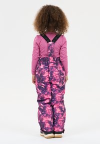 Ski overalls in pink and purple galaxy pattern, made of water-resistant fabric, with adjustable black straps and elastic waist, featuring reinforced cuffs.