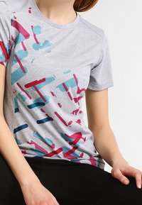 Kurzärmliges graues T-Shirt mit einem mehrfarbigen, abstrakten Muster in Türkis und Burgunderrot. Weicher Stoff mit Rundhalsausschnitt und lockerer Passform.