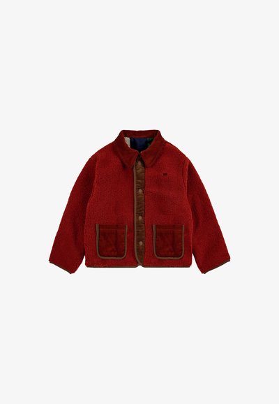 Red fleece jacket with brown corduroy front panel, two large front pockets, and a collar. Features snap button closure and textured fabric.