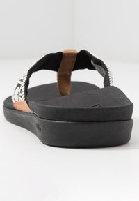 Zwarte flip-flop sandaal met gevlochten stoffen band met een bruin accent en een getextureerde, gevoerde voetbed voor comfort.