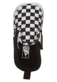 Černobílé kostkované slip-on boty s textilním svrškem, gumovou podešví a poutkem na patě pro snadné obutí. Značka Vans je viditelná uvnitř.