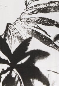 Svartvit textil med djärva, grafiska silhuetter av palmer med fina detaljer och varierande texturer på en ljus bakgrund.