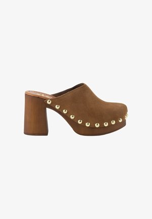 Zueco marrón de ante con tacón alto de bloque de madera y tachuelas doradas decorativas a lo largo de los laterales y el borde frontal.