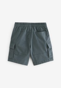 Pantaloni cargo verdi in cotone con vita elasticizzata, tasche laterali e schiena piatta. Tessuto resistente con una superficie liscia e design funzionale.