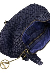 Woven navy leather handbag with gold hardware, zip closures, and a tassel. Interior features a soft blue lining and zippered pockets.