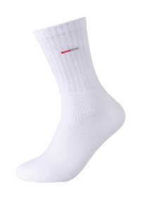 Hvide bomuldsstrømper med ribbet tekstur, en polstret sål og en lille rød og beige logo-stribe nær toppen.