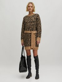 Leopardenmuster-Strickkleid in Beige und Schwarz mit einem taillierten Gürtel. Kombiniert mit kniehohen schwarzen Stiefeln und einer schwarzen Schultertasche. Sanfte Textur.