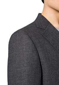 Ciemnoszary żakiet o teksturowanej tkaninie, z klapami w szpic i wyraźnie zarysowanymi ramionami, z widocznym szwem ramienia i częścią kołnierza.