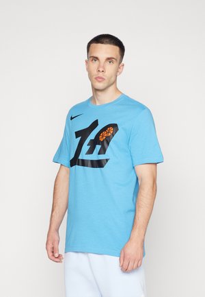 Camiseta de algodón azul con mangas cortas, que presenta un gran gráfico negro y un diseño de baloncesto naranja en la parte frontal. Corte regular, cuello redondo.
