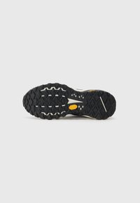 Black rubber outsole with deep lugs for traction, featuring a Vibram logo in orange. Designed for durability and grip on varied terrains.
