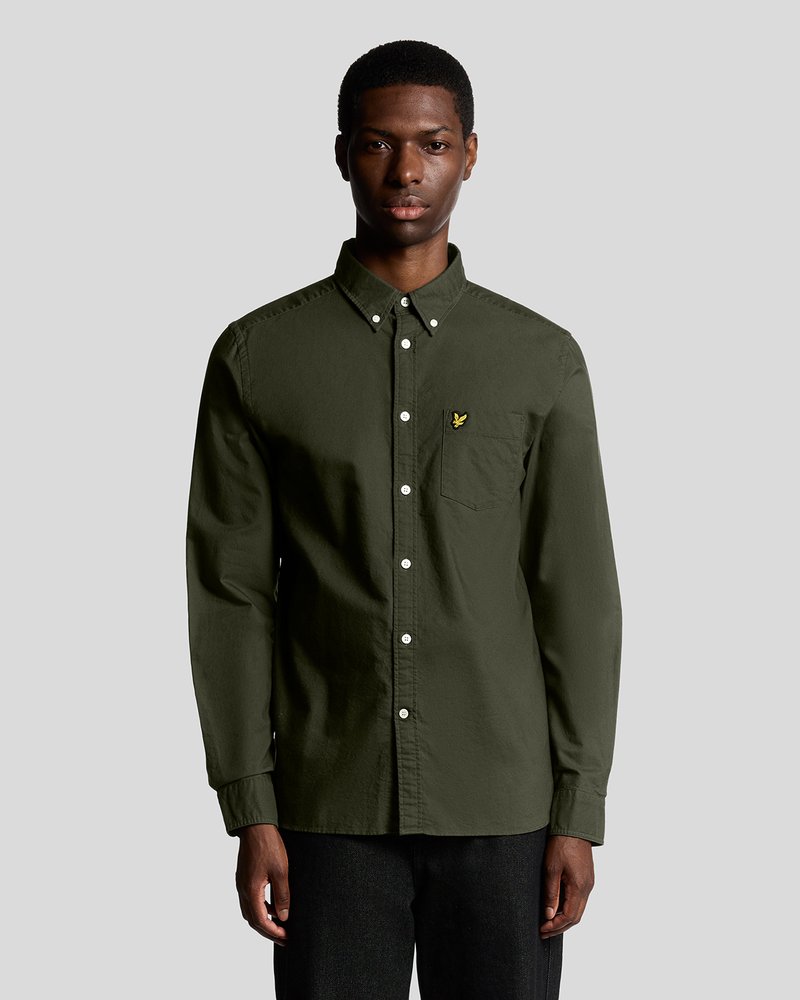Camisa de manga larga verde oscuro en tejido suave, con cuello tipo polo, botones blancos y un pequeño logo bordado en el pecho.