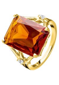 Bague en or ornée d'une grande pierre précieuse rectangulaire orange-rouge avec des facettes, accentuée par deux petites pierres claires de chaque côté.