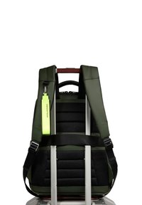 Green backpack with padded black mesh back and adjustable straps, featuring a neon green tag and a silver pull handle at the top.