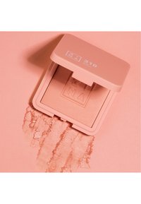 Rosa blush kompakt med en jevn pudroverflate i et matchende etui; har en logo på lokket og fargeprøve under.