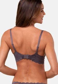 Szary koronkowy biustonosz z regulowanymi ramiączkami, zapięciem na haczyk, falbaniastymi brzegami i gładką fakturą, widoczny z tyłu, prezentujący misterną szczegółowość.