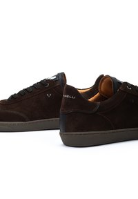 Zapatillas de ante marrón con acentos negros, punta redonda, superficie texturizada, cordones planos y suela de goma, con detalle del logo en el talón.