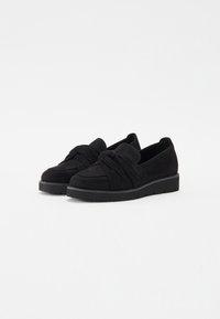Svarta mocka slip-on-skor med en knuten design fram, med en texturerad yta och en svart gummisula.