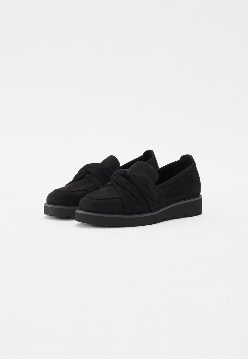 Schwarze Wildlederschlüpfschuhe mit einem geknoteten Design an der Vorderseite, ausgestattet mit einer strukturierten Oberfläche und einer schwarzen Gummisohle.