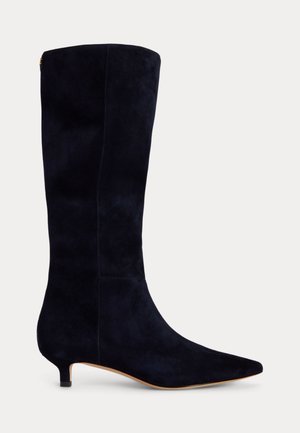 Botte haute en daim noir avec bout pointu et petit talon kitten sur fond uni.