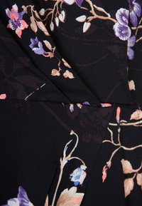 Czarna tkanina z motywem floralnym w kolorach purpurowym, różowym i beżowym. Posiada plisowany wzór z widocznymi szwami i gładką fakturą.