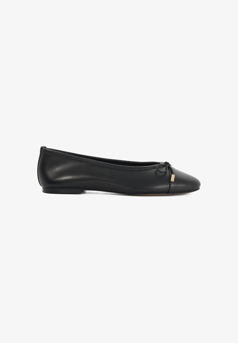 Ballerine plate en cuir noir avec un petit nœud et un détail doré à l'extrémité, dotée d’un petit talon et d’une forme arrondie à l'avant.