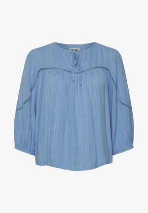 Jasnoniebieska bluzka z okrągłym dekoltem, detalem w postaci wiązania i rękawami o długości trzech czwartych. Posiada pionowe paski i marszczoną fakturę.