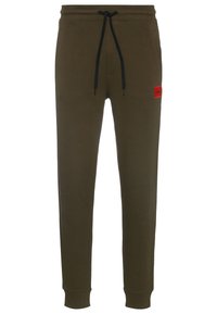 Olivgrüne Sweatpants aus weichem Stoff, mit elastischem Bund, schwarzen Kordeln und einem roten Markenpatch am linken Bein.
