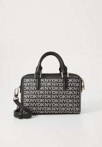 Black and white patterned handbag with top handles, zip closure, and adjustable shoulder strap. Features logo design and gold-tone hardware accents.