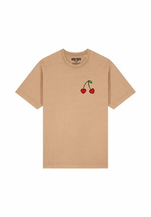 Een tan kleurige katoen t-shirt met een afbeelding van twee rode kersen met groene bladeren, korte mouwen en een ronde hals.