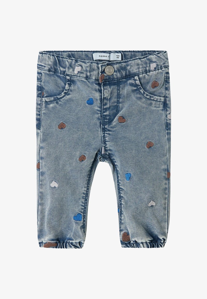 Jeans para toddlers en azul claro con tobillos elásticos, bordados con pequeños corazones en marrón, azul y blanco, y cierre de botón de metal.