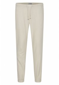 Pantalones jogger de algodón de color beige claro, con cintura elástica, cordón ajustable y puños ajustados. Textura suave sin patrones visibles.