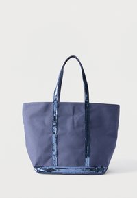 Sac fourre-tout en toile bleu marine avec des poignées et un bord ornés de sequins brillants, debout à la verticale sur un fond blanc.