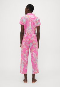 Rozā, rakstaina īsām piedurknēm krekla un īsa biksu komplekts ar paisley dizainu vairāku krāsu toņos. Kokvilnas materiāls ar brīvu piegriezumu.