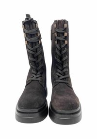 Stivaletti neri in suede con stringhe, dotati di una robusta suola in gomma, con una superficie testurizzata, dettagli metallici e una zip laterale per indossarli facilmente.