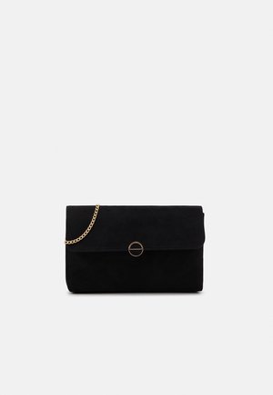 Pochette rectangulaire noire avec fermeture à rabat et fermoir circulaire doré, dotée d'une courte chaîne dorée sur un fond uni.