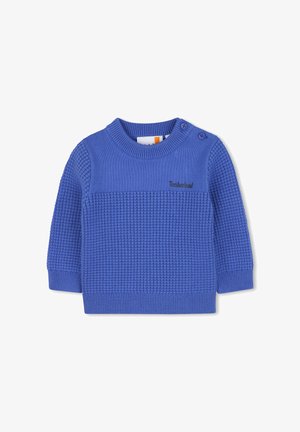 Blauwe gebreide trui met een gestructureerd patroon, ronde halslijn en twee knoopaccenten op de schouder. Bevat een subtiel logo.