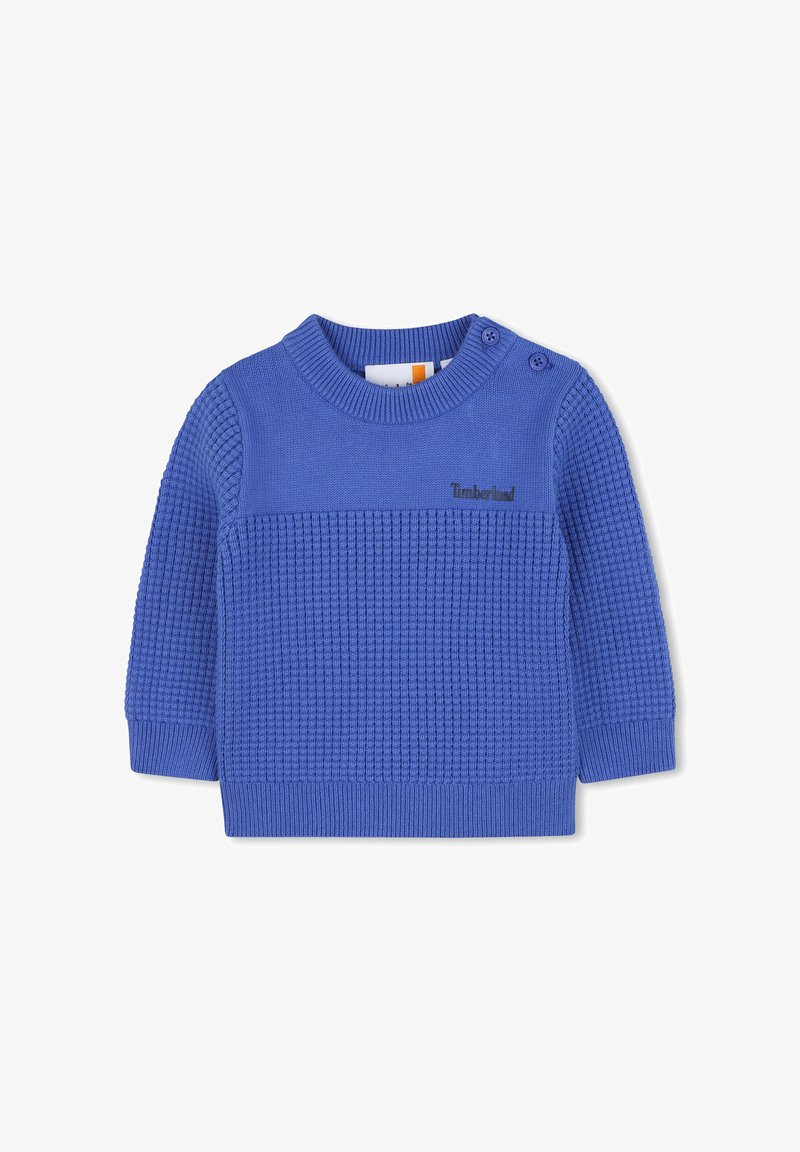 Blauwe gebreide trui met een gestructureerd patroon, ronde halslijn en twee knoopaccenten op de schouder. Bevat een subtiel logo.