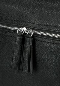 Schwarze, texturierte Ledertasche mit einem silbernen Reißverschluss und zwei schwarzen Lederquasten. Das Markenlogo "Gabor" ist auf der Oberfläche eingraviert.