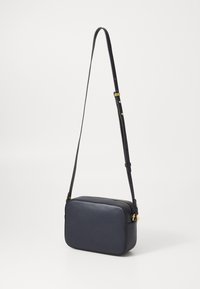 Borsa a tracolla in pelle blu navy con forma rettangolare, dettagli in metallo dorato, tracolla regolabile e chiusura con zip visibile.