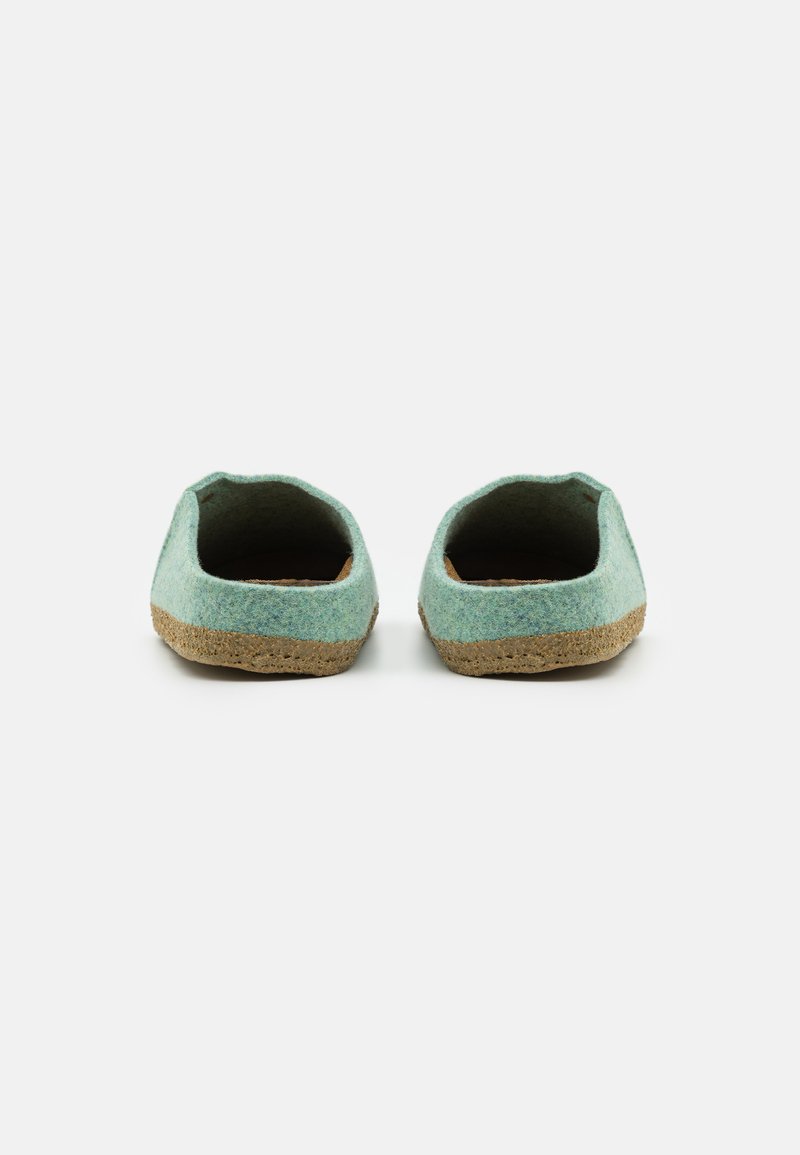 Grüne Filzslipper mit runder Form, strukturierter Oberfläche und beige Gummisohlen. Offenes Rückendesign für ein einfaches Anziehen.