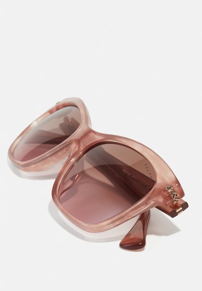 Occhiali da sole oversized rosa con montatura trasparente rosata, lenti sfumate e un accento dorato sulla tempia. Finitura texture.