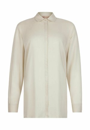 Langes, cremefarbenes Hemd mit verdeckter Knopfleiste und spitzem Kragen, frontal auf weißem Hintergrund präsentiert.