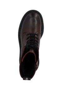 Botín de cuero marrón con cordones negros, suela de goma resistente, puntera reforzada y forro interior rojo. Superficie texturizada, forma redonda.